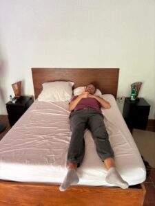 Grosser Mensch im zu kurzen Bett